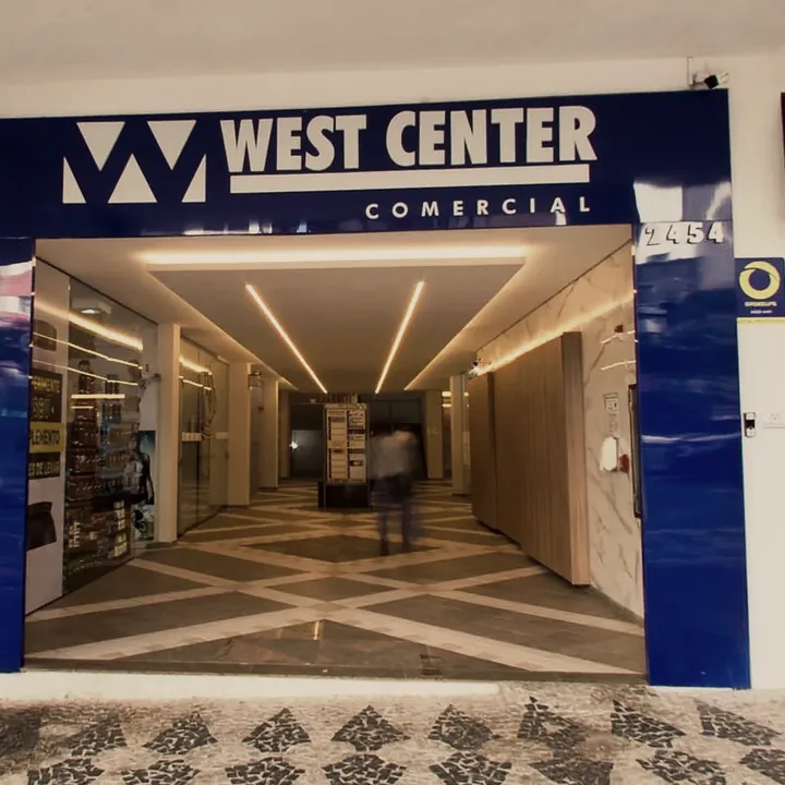 Entrada do West Center Comercial: portal com o nome do prédio, o número 2454 e a calçada de petit-pavé